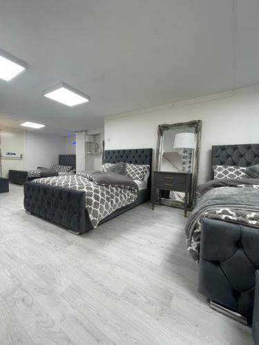 1 dormitorio con 2 camas y espejo en Cwtch Cardiff Bay, en Cardiff