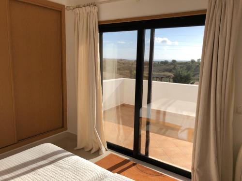 1 dormitorio con vistas a una bañera y una ventana en VILLA Casa Eden en Vila Nova de Cacela