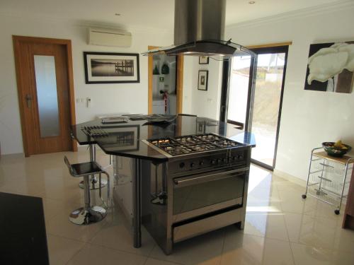 a kitchen with a stove and a counter top at VILLA Casa Eden in Vila Nova De Cacela