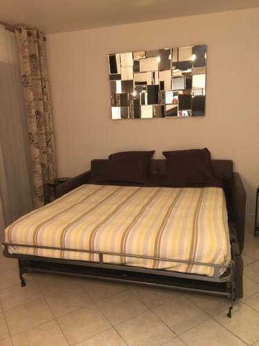 a bed in a bedroom with a mirror on the wall at Hyper centre Deauville in Deauville