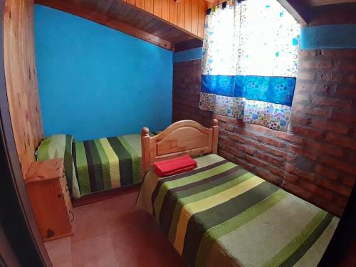 a small room with two twin beds in a room at Alojamiento Puesta del Sol in El Bolsón