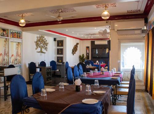 une salle à manger avec des tables et des chaises bleues dans l'établissement Baba Palace - A Heritage Hotel, Udaipur, à Udaipur