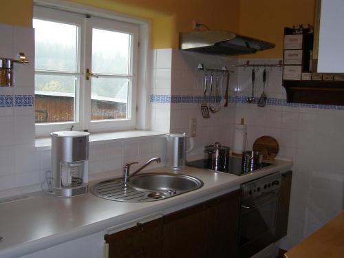 eine Küchentheke mit einem Waschbecken und einem Fenster in der Unterkunft Ferienhaus Brotenfeld in Brotenfeld