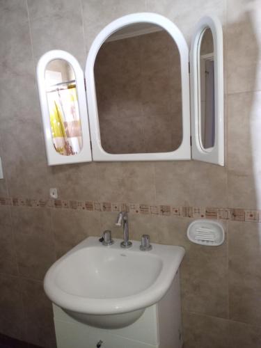 uma casa de banho com um lavatório e 2 espelhos em Jugueze Tres Arroyos II em Tres Arroyos