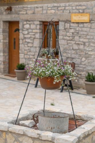 a flower pot on a stand with a pot of flowers at villa Melissa in Kostitsi