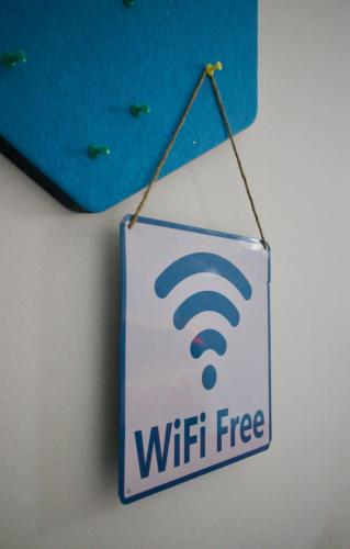 a sign that reads wifi free hanging on a wall at GOT Prishtina Hostel in Pristina
