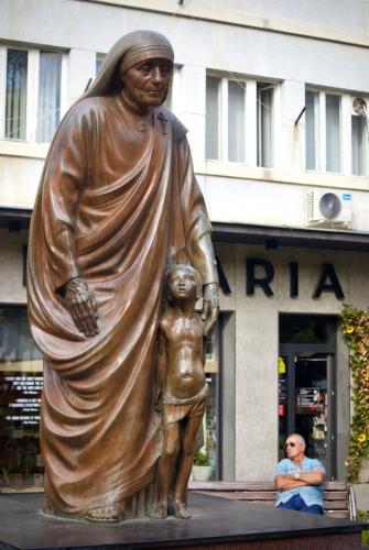 a statue of a woman and a child in front of a building at GOT Prishtina Hostel in Pristina