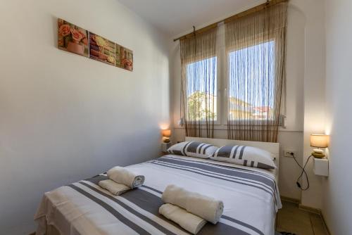a bedroom with a bed with two pillows on it at Diva Apartment in Povljana