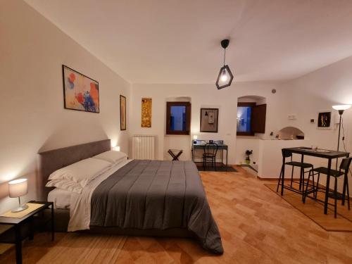 a bedroom with a bed and a kitchen with a table at G.S House in LʼAquila