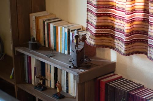 a book shelf filled with books next to a window at villa Melissa in Kostitsi