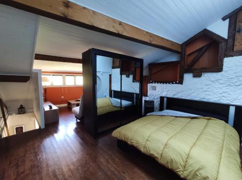 une chambre avec un lit et un miroir dans l'établissement La Petite Maison Neuvecelle - Maison de village, à Neuvecelle