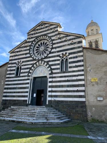 une église noire et blanche avec une horloge sur elle dans l'établissement Sant'Andrea Appartamento nel borgo antico, à Levanto
