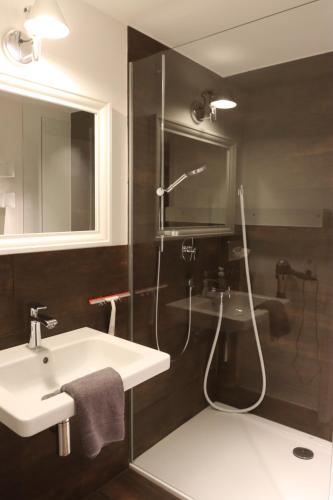 a bathroom with a sink and a shower with a shower at The Birdy Mountains Luxury Lodge 2, 230qm,Sauna,Entertainment in Schlitz