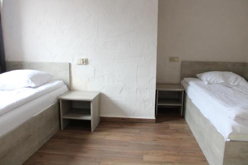 two beds in a room with two tables at Wodny Świat in Ostrzyce