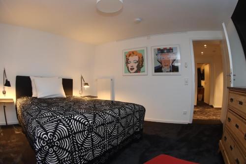 um quarto com uma cama em preto e branco e uma cómoda em The Birdy Mountains Luxury Lodge 2 em Schlitz