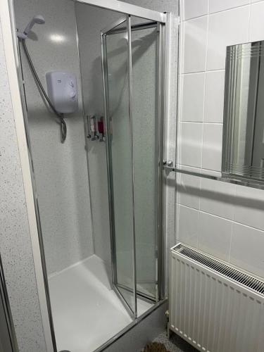 a shower with a glass door in a bathroom at Charlies in Skegness