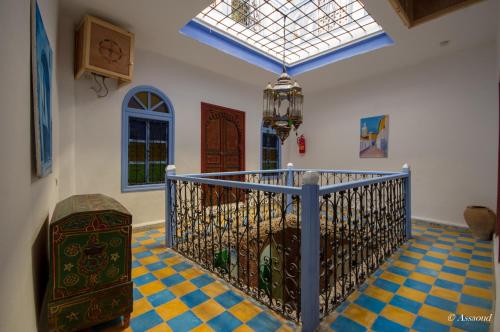 Zimmer mit einer Treppe, einem Fenster und Fliesenboden in der Unterkunft Dar El Fanne in Chefchaouen