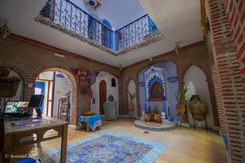 Dar El Fanne في شفشاون: غرفة معيشة مع جدار من الطوب وسقف
