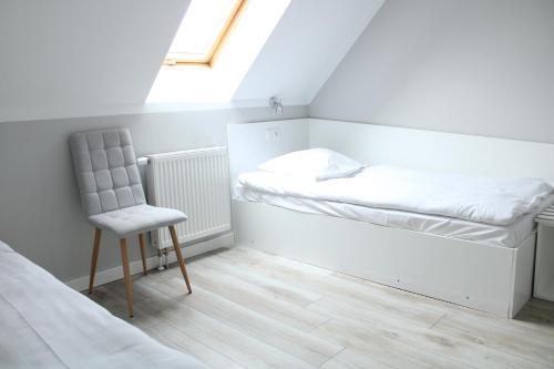 a bedroom with a bed and a chair and a window at Wodny Świat in Ostrzyce
