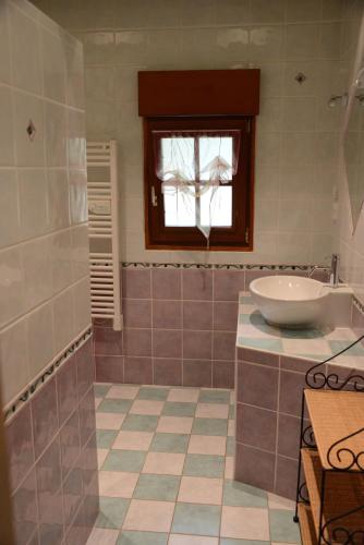 une salle de bain avec une baignoire, un lavabo et une fenêtre dans l'établissement Le Clos du Rossignol, à Le Tartre