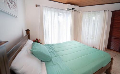 a bed in a room with a large window at Apartamentos Cristal in Quepos