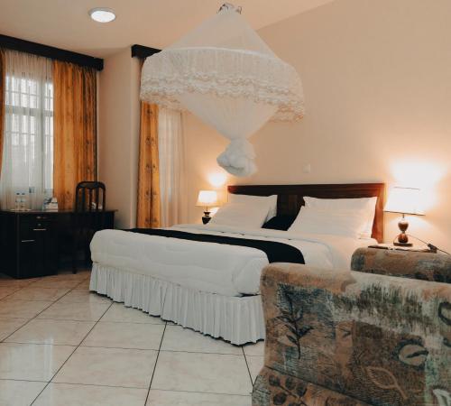 um quarto com uma cama grande e um sofá em Centre Saint Vincent Pallotti em Kigali