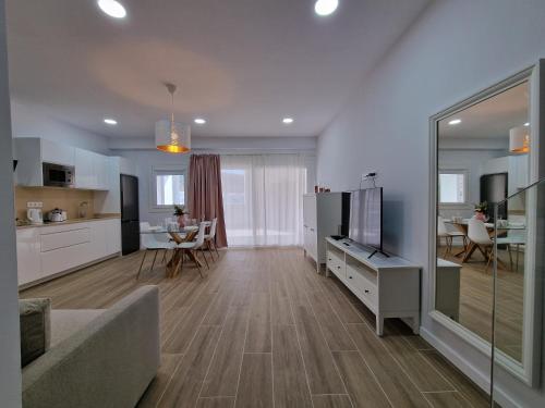 uma sala de estar com um sofá, uma televisão e uma cozinha em Alojamientos Agaete Pueblo Nº3, Nº4, Nº5, Nº6 em Agaete
