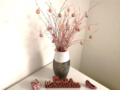 a vase sitting on a table with a christmas tree at Ferienwohnung Bad Säckingen ruhig und zentral in Bad Säckingen