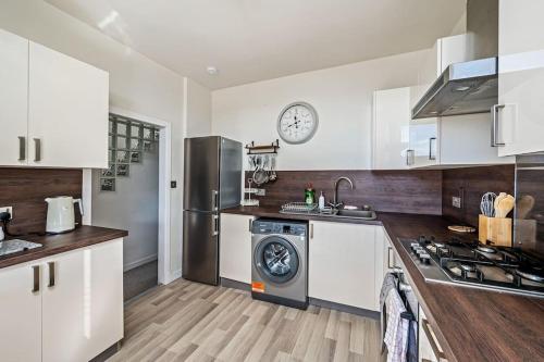 a kitchen with white cabinets and a washer and dryer at Broughty Ferry Riverview Apt -3 bedroom -Sleeps 7 in Broughty Ferry