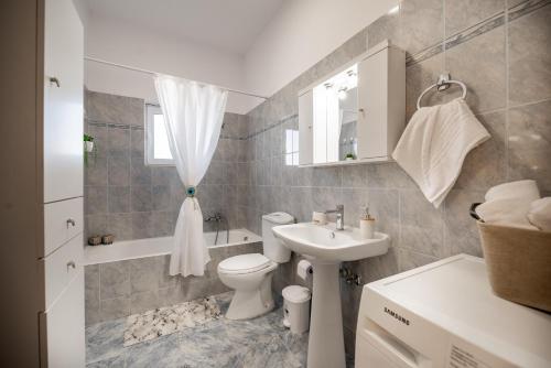 a bathroom with a toilet and a sink and a tub at Katerina's House in Afantou