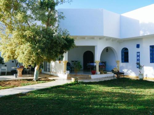 een wit huis met een boom in de tuin bij Dar Balti - Hammamet Nord in Hammamet Nord