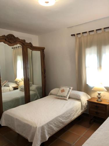 una camera da letto con due letti e uno specchio di Finca San Andrés a Santa Eulalia