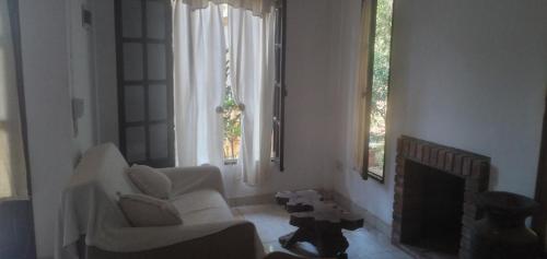 - un salon avec deux chaises blanches et une cheminée dans l'établissement Posada Enki, à Puerto Iguazú