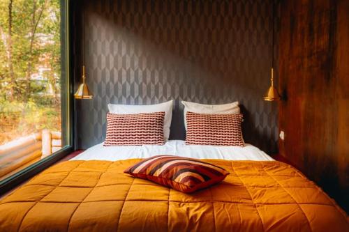 een bed met twee kussens en een raam bij Coco’s Buitenhuisje in Nunspeet