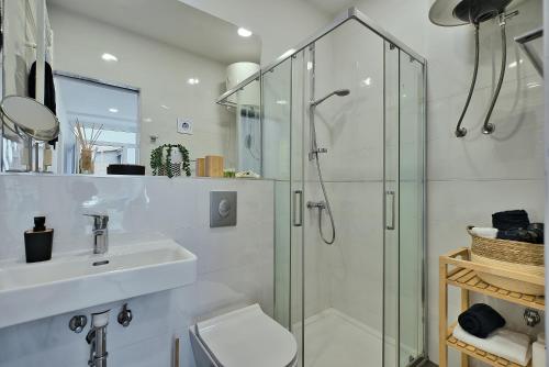 a white bathroom with a shower and a sink at Aurea City Center Apartment Zagreb in Zagreb
