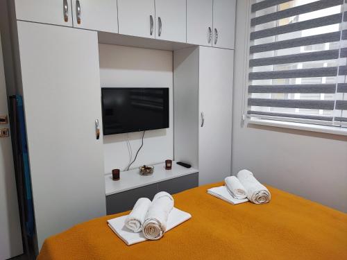 a room with a table with white towels and a tv at White pearl & SPA in Veliko Gradište