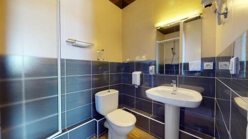 a bathroom with a toilet and a sink at Hôtel de France Contact-Hôtel in Évian-les-Bains