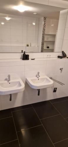 a bathroom with two sinks and a mirror at Homey Apartments Harbor Suite - Parking Two Bathrooms Netflix Sea view in Bremerhaven
