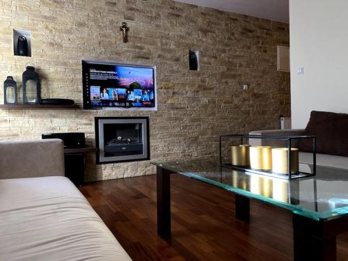 a living room with a glass table and a tv at Apartament 2 pokojowy 5min od Krupówek z garażem in Zakopane