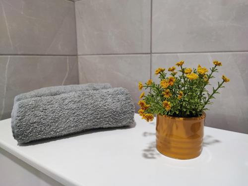 a vase of flowers on a table with a towel at White pearl & SPA in Veliko Gradište