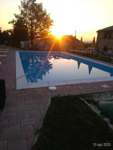 una piscina con puesta de sol en el fondo en AFFITTACAMERE LA QUIETE en San Marcello
