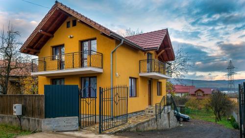 a yellow house with a fence in front of it at Casa Luna in Cluj-Napoca