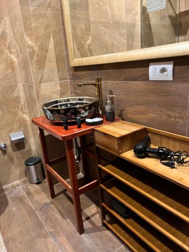 y baño con lavabo sobre una mesa de madera. en Amo's Hotel, en Shkodër