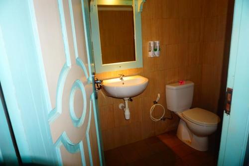ギリ・トラワンガンにあるローズ ホームステイのバスルーム(洗面台、トイレ、鏡付)