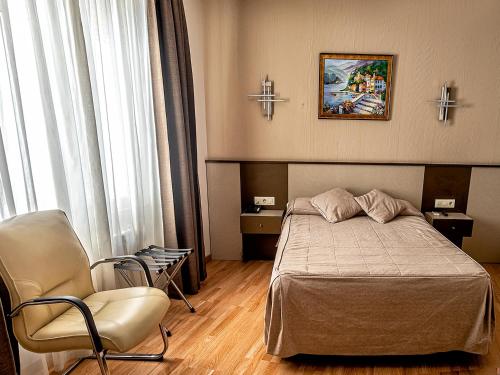 a hotel room with a bed and a chair at Hostal Real Aranjuez in Aranjuez