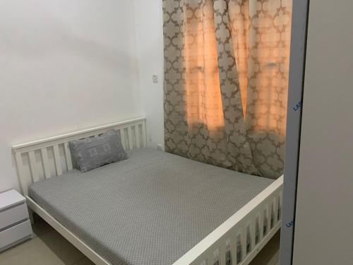 a small bed in a room with a curtain at Cheerful 3 bedroom bungalow, Fatty Boulevard in Madina Sey Kunda