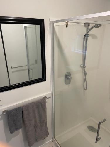 a shower with a glass door in a bathroom at Ohope Beach Dreamer in Ohope Beach