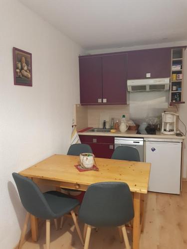 a kitchen with a wooden table and four chairs at B&B &Cot in La Ferrière