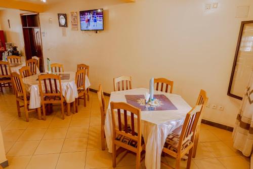 a dining room with tables and chairs and a tv at Centre Saint Vincent Pallotti in Kigali