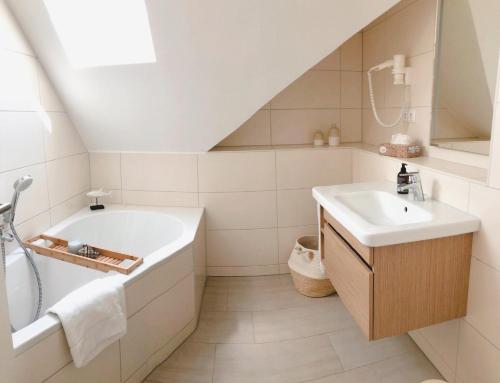 a white bathroom with a tub and a sink at PerlePlau in Plau am See